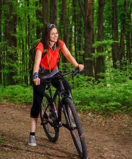 A relaxing spa experience at Ojaswi Resort, showing a woman receiving a hot stone massage against a scenic mountain backdrop.