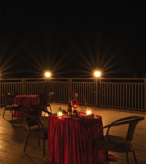 Romantic candlelight dinner setup at Ojaswi Resort in Mukteshwar with softly lit tables overlooking the peaceful night view