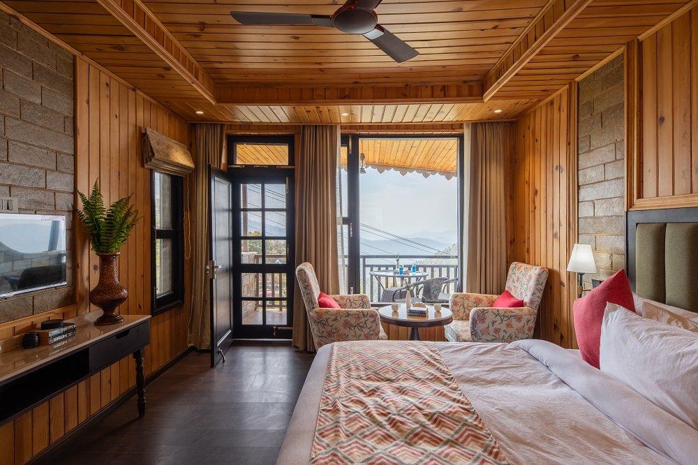 Sunset Retreat room at Ojaswi Resort Mukteshwar featuring private balcony with uninterrupted Himalayan valley views.