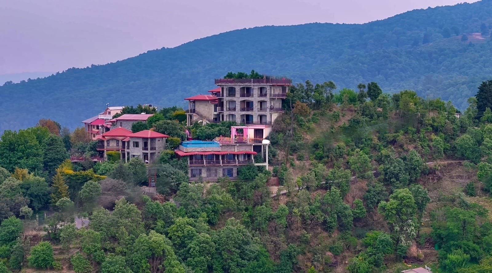 Grand hill top wedding venue at Ojaswi Resort with a scenic forest backdrop and beautiful evening illuminations.