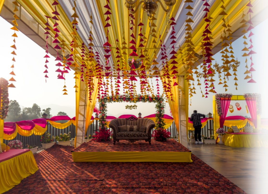 Vibrant Mehndi ceremony decor at Ojaswi Resort, featuring colorful outdoor seating and scenic mountain views.