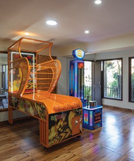 Indoor arcade game room at Ojaswi Resort featuring a basketball machine and punching game.
